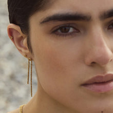 Charger l'image dans la galerie, Boucles d’oreilles Étreinte BDM Studio dorées à l’or fin portées à l’oreille
